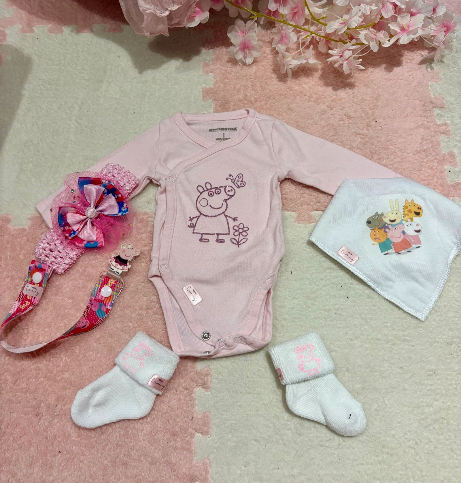 Ensemble bébé – Body + bavoir + attache tétine + bandeau + chaussettes